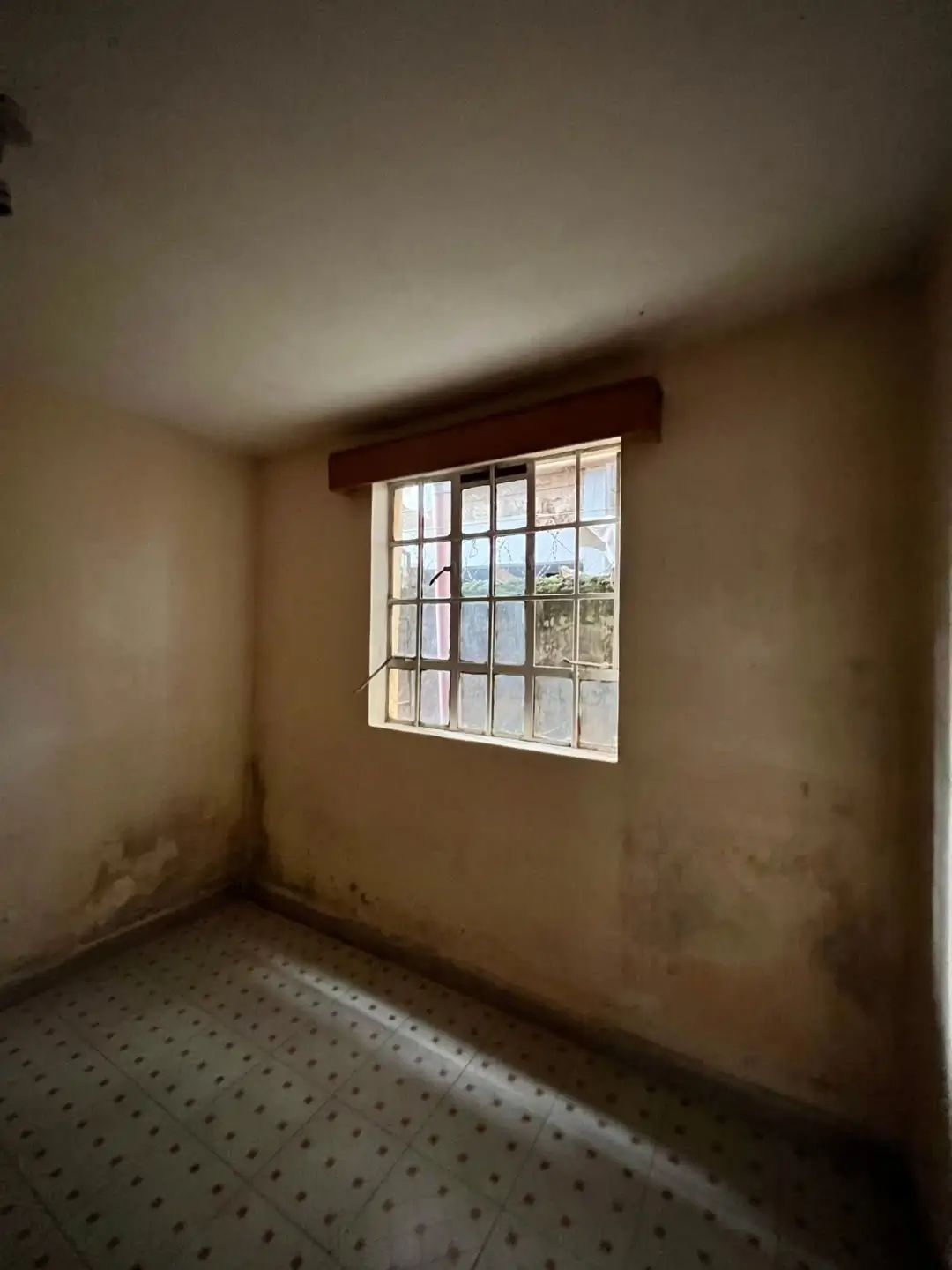Empty bedroom with window and wooden cornice detail