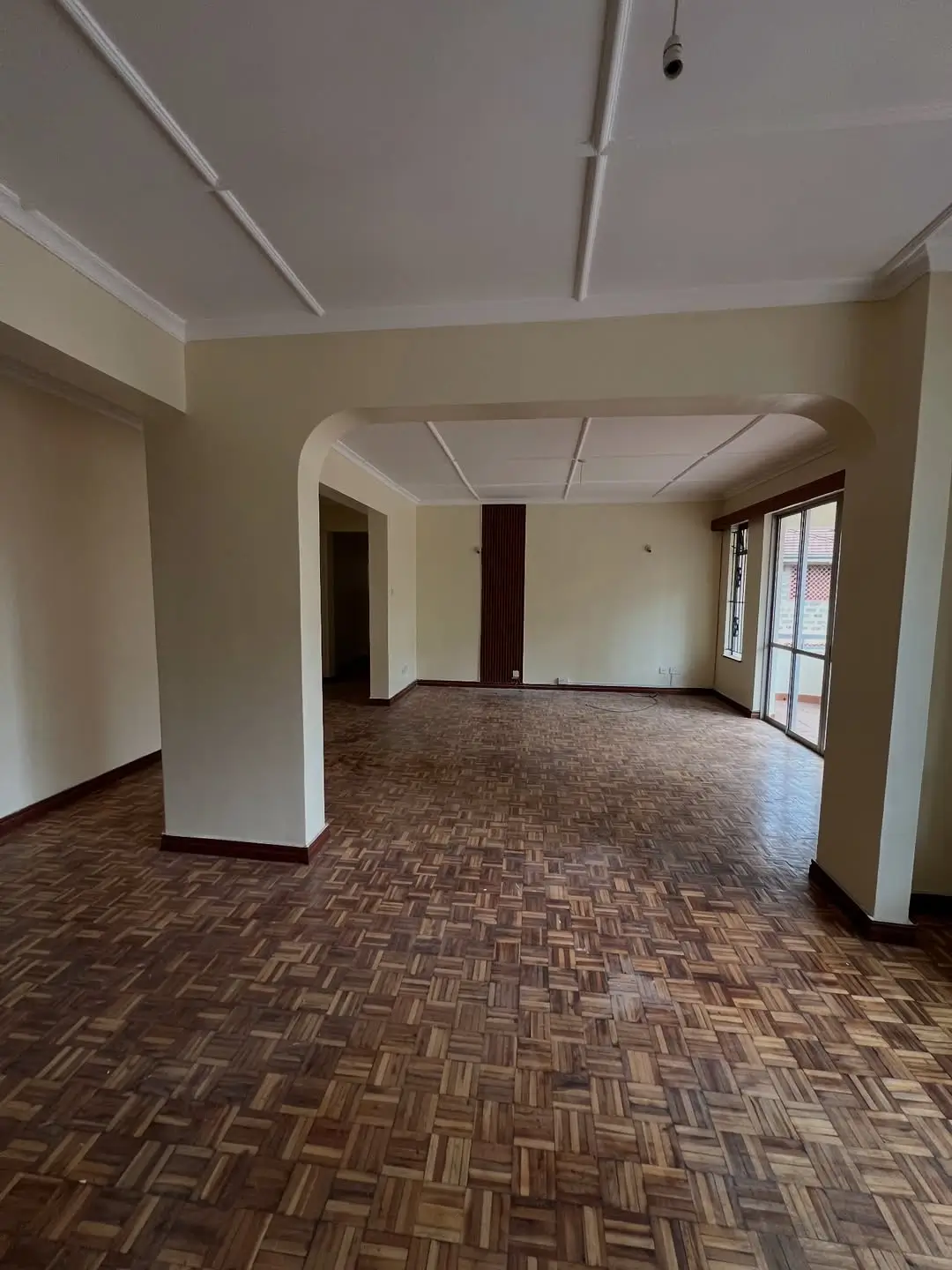 Spacious open-plan living area with herringbone wooden flooring