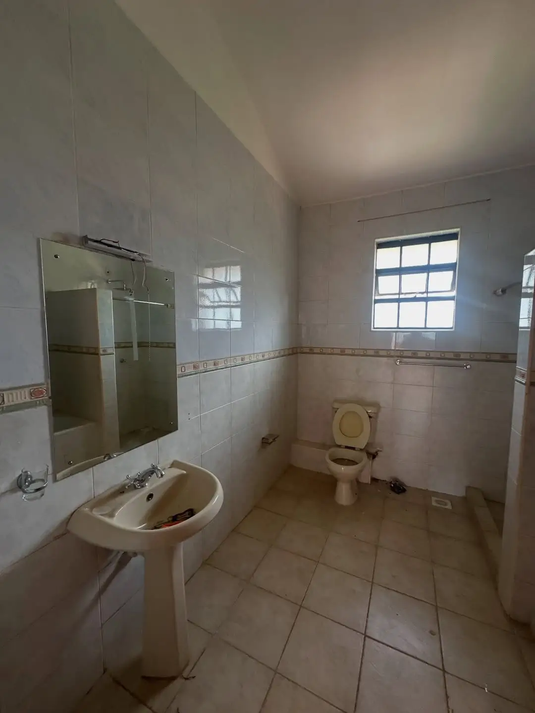 Spacious bathroom with pedestal sink and toilet fixture
