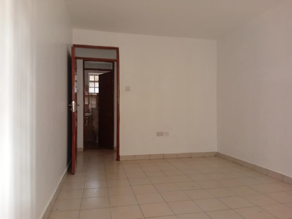 Empty living room with tiled floor and red-framed doorway