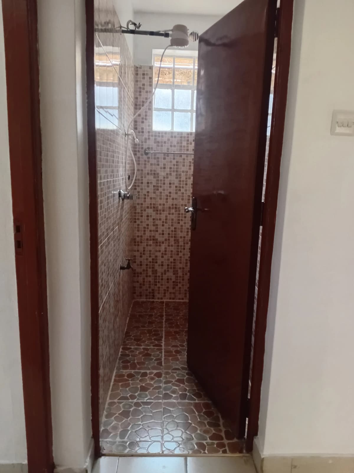 Narrow shower room with mosaic tile walls and floor