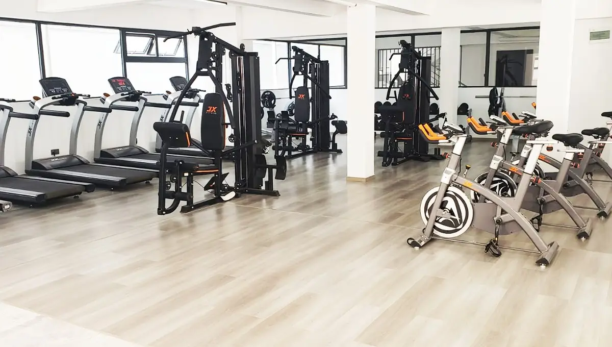 Modern gym with treadmills, weight machines, and spin bikes
