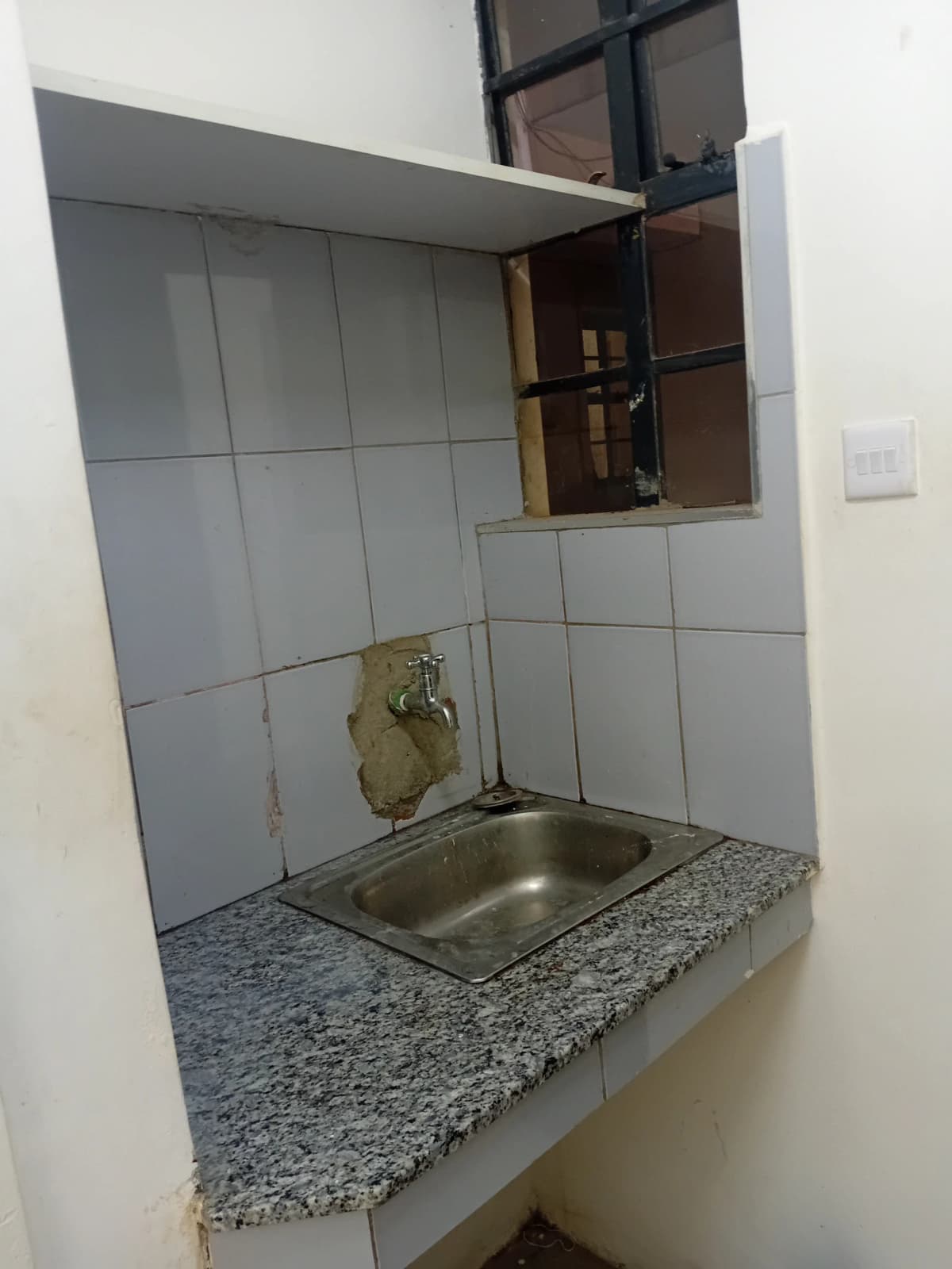 Compact kitchen with stainless steel sink and granite countertop