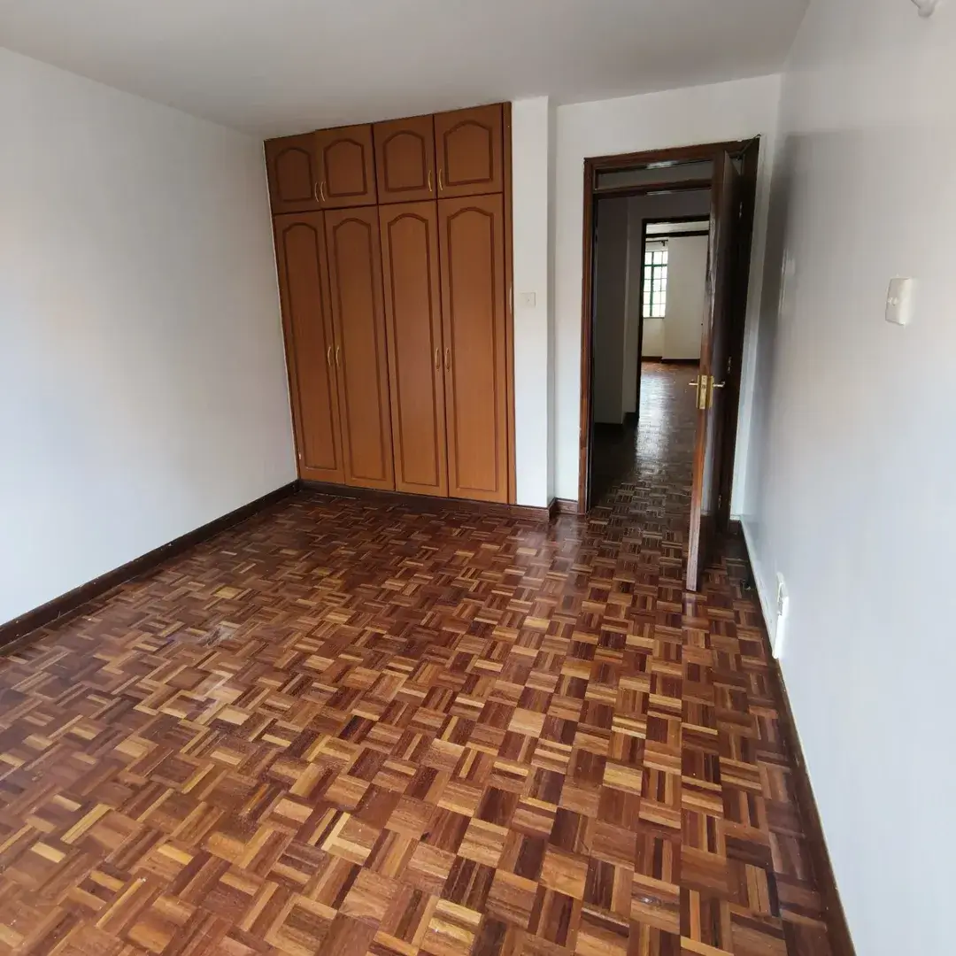 Spacious bedroom with wooden wardrobe and herringbone flooring