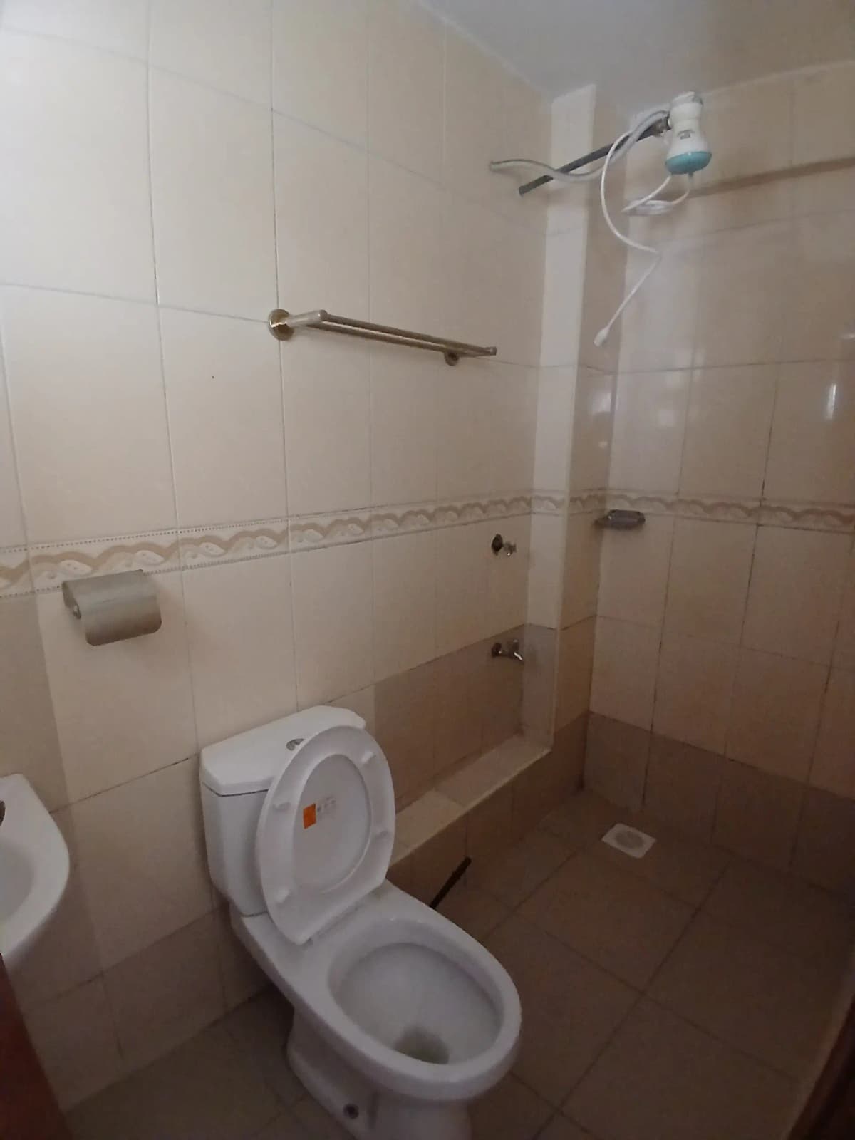 Basic bathroom with toilet, shower, and tiled walls