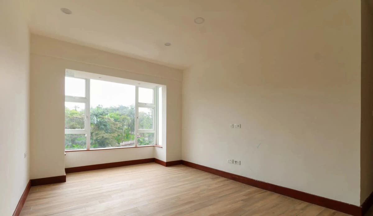 Spacious bedroom with large windows and wooden flooring