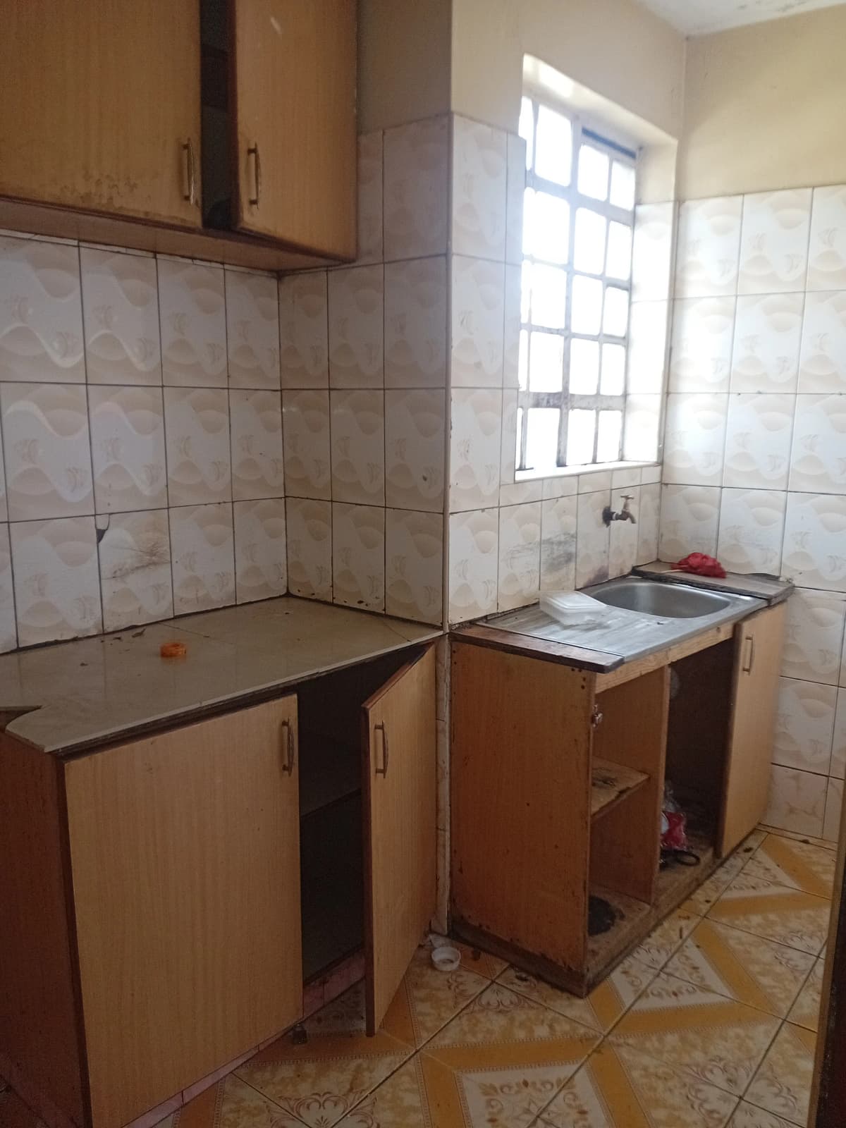Compact kitchen with wooden cabinets and tiled walls