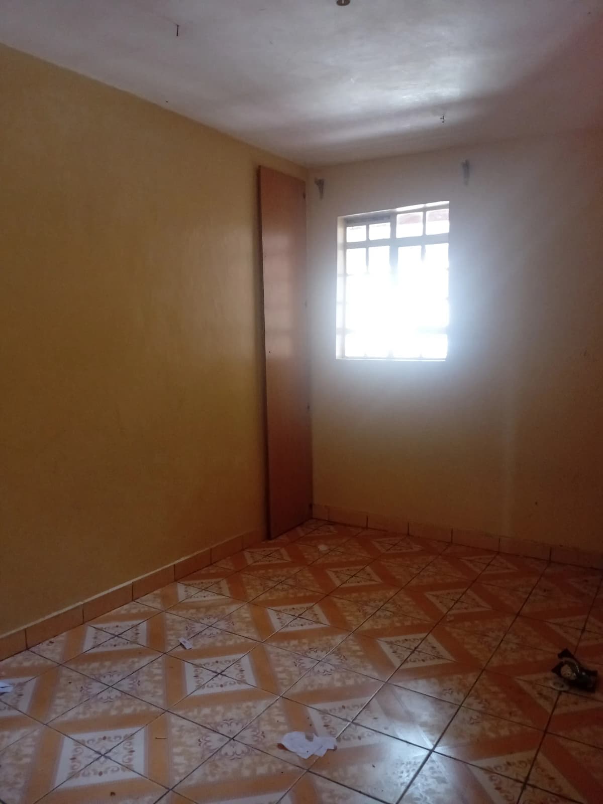 Empty bedroom with terracotta tiles and natural light
