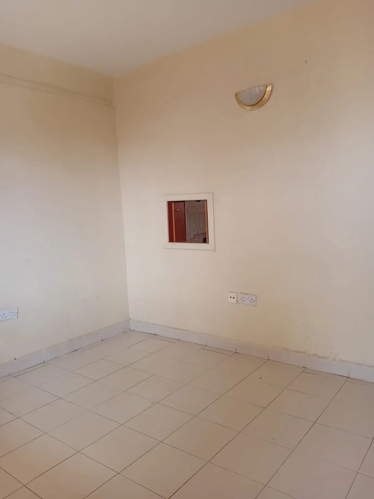 Empty bedroom with tiled flooring and minimal fixtures