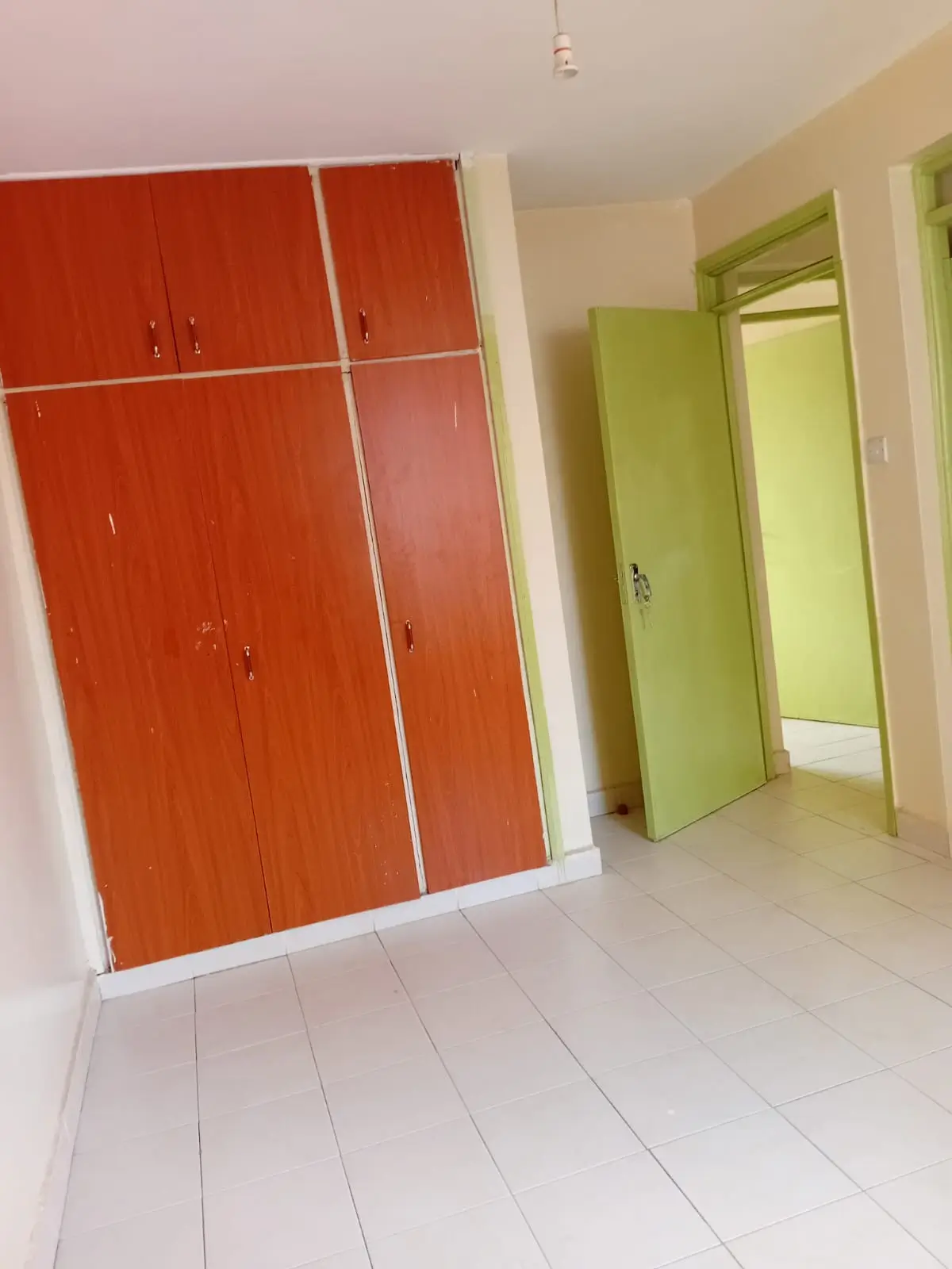 Bedroom with red built-in wardrobes and white flooring