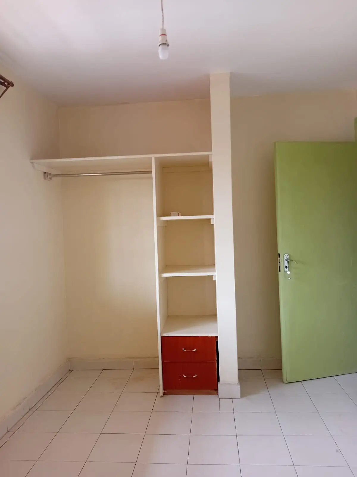 Unfurnished bedroom with built-in wardrobe and shelving