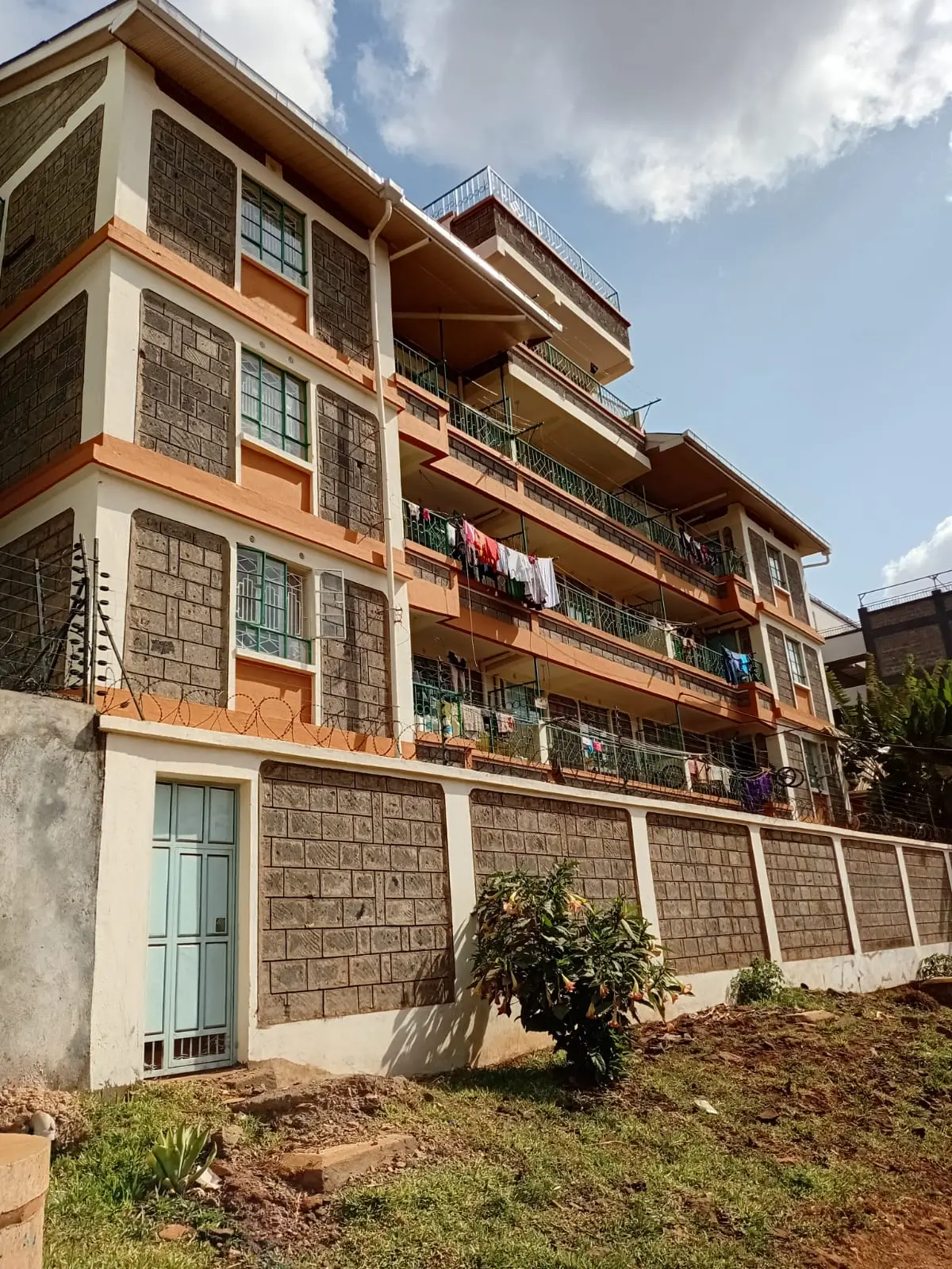 Multi-story residential building with stone facade and balconies