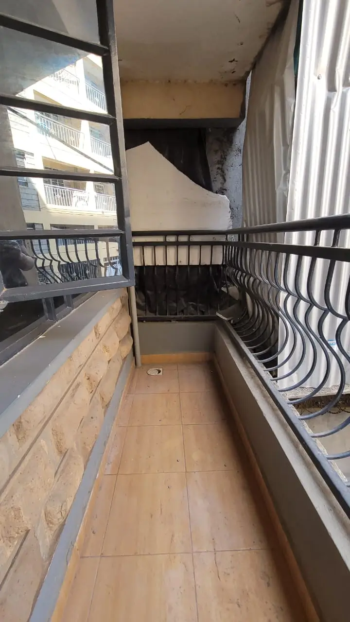 Narrow balcony with wooden flooring and metal railings