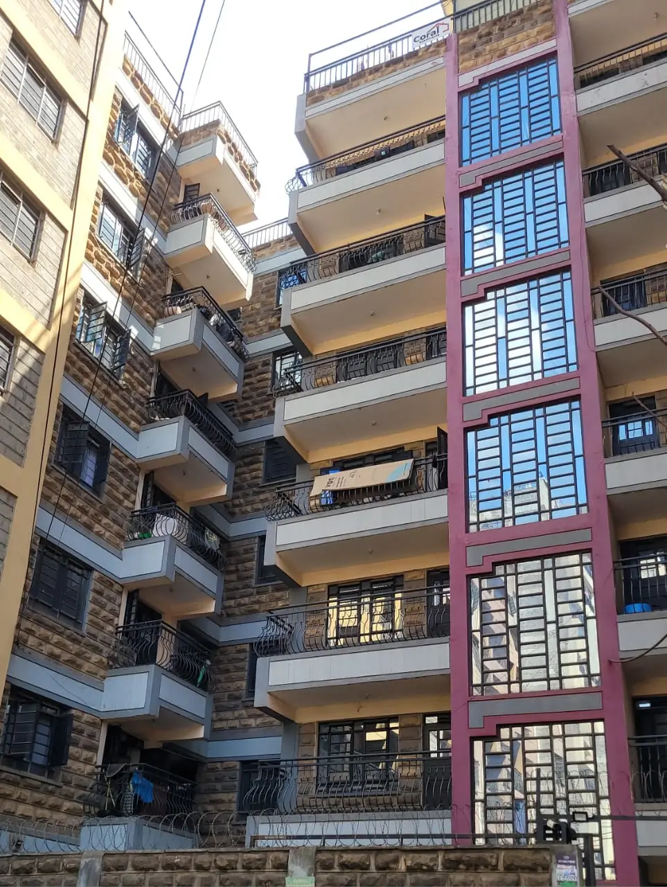 Multi-story residential building facade with balconies and shutters