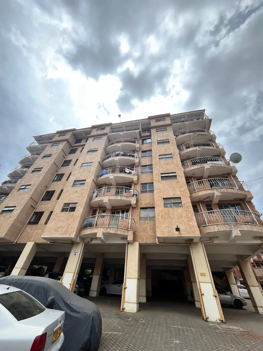 Multi-story residential building facade with ground-level parking bays