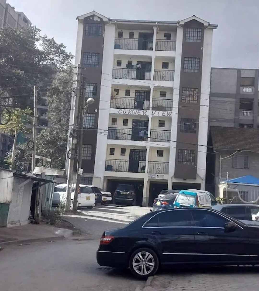 Multi-story residential building facade with ground-level parking