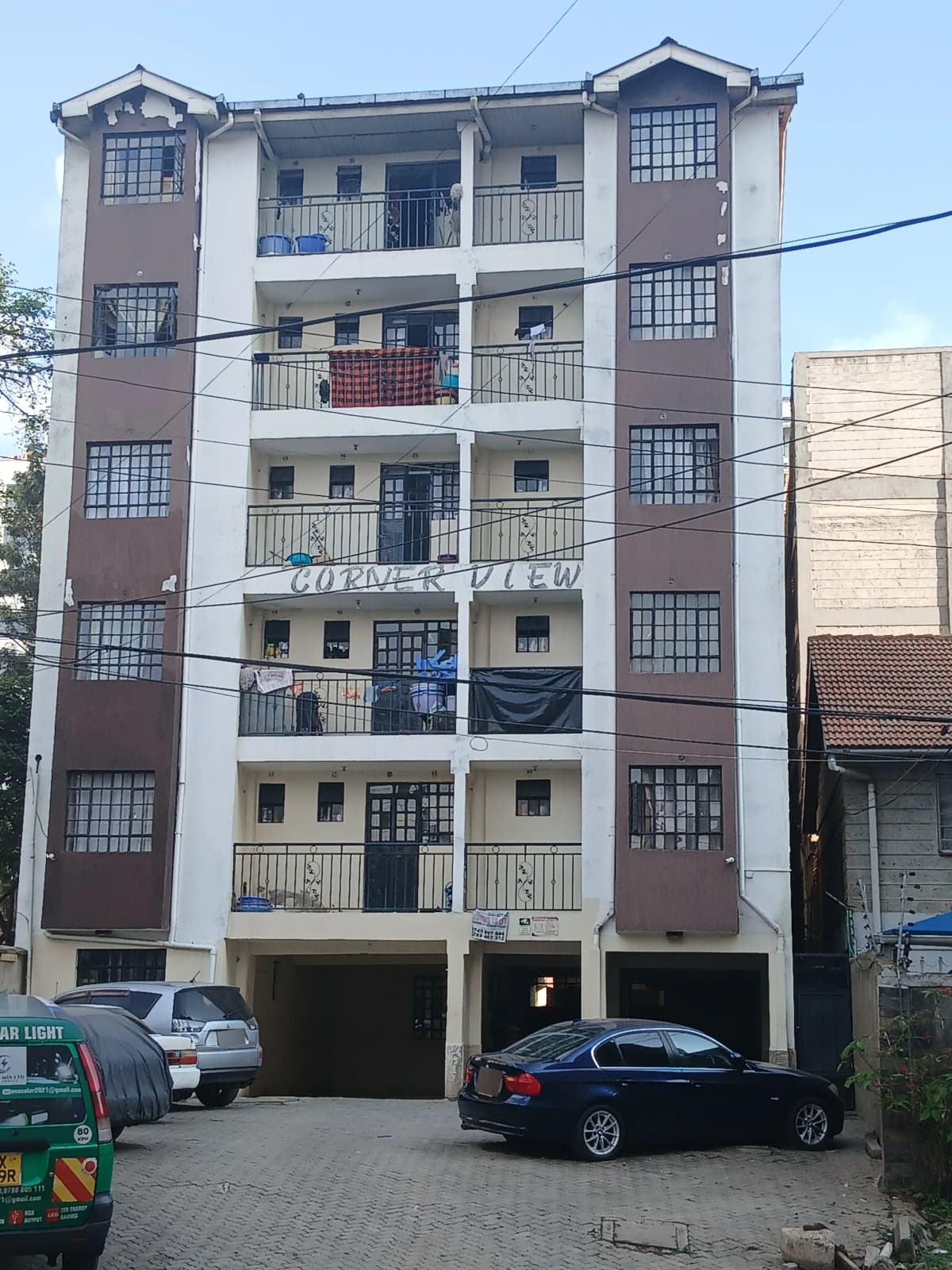 Multi-story residential building facade with balconies and parking