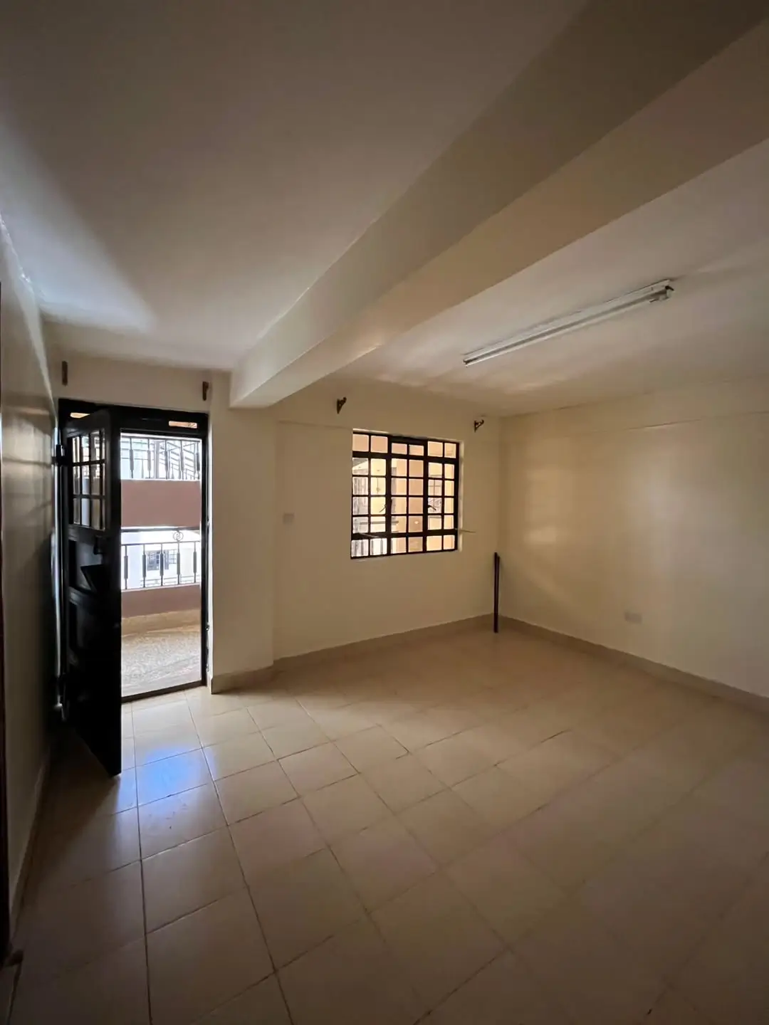 Empty living room with tiled floors and natural light
