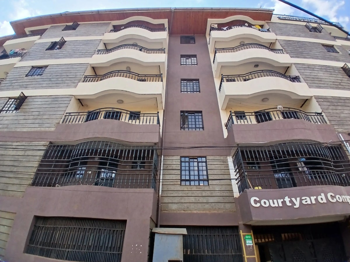 Multi-story residential building facade with balconies and ground-floor commercial