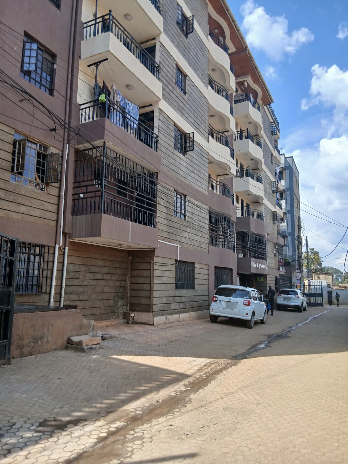 Multi-story residential building facade with parked vehicles