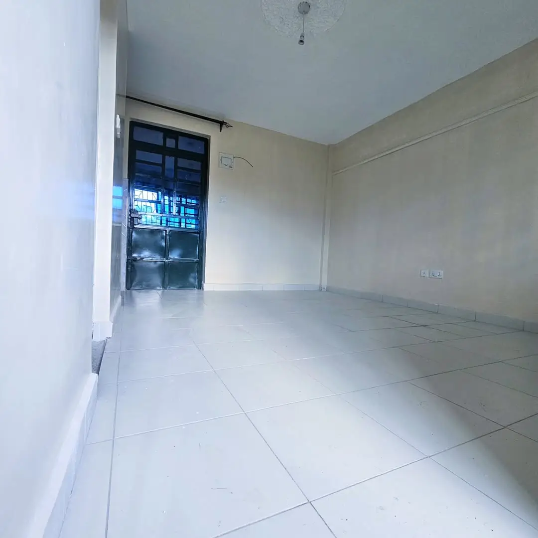 Empty living room with tiled floor and blue door.