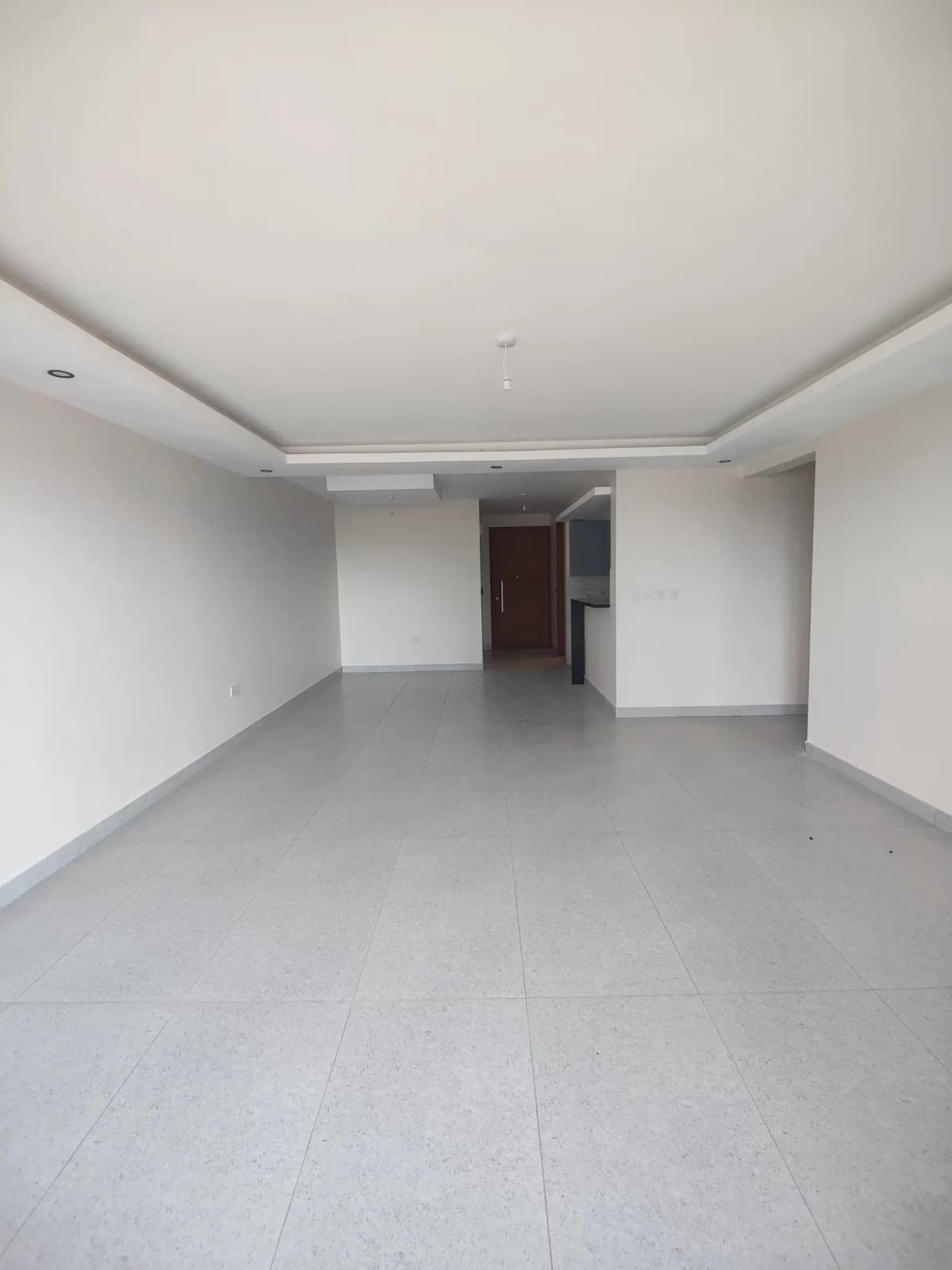Spacious empty living room with polished grey tile flooring