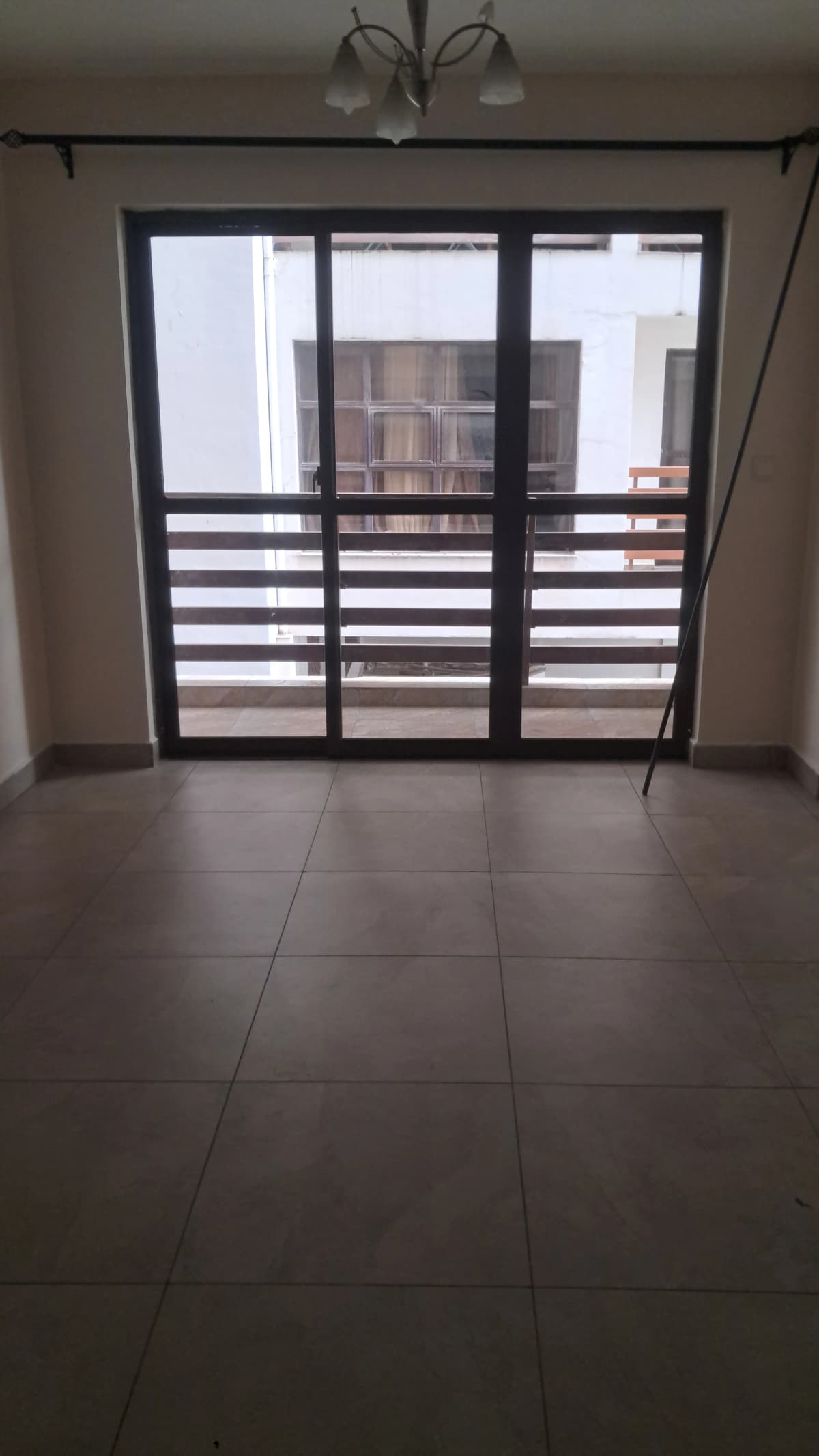 Balcony with black louvered sliding doors and tile flooring