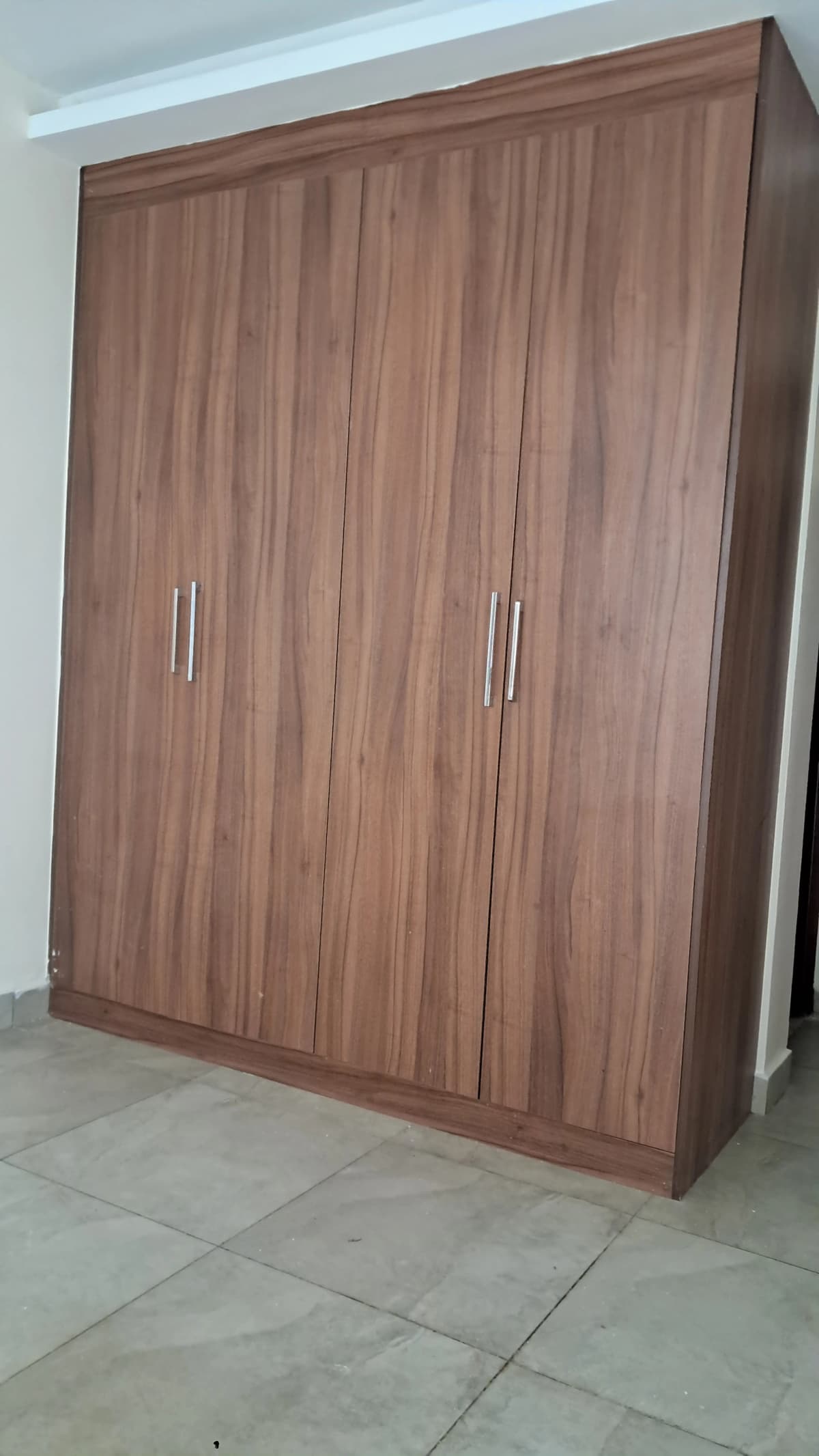 Large wooden four-door wardrobe in bedroom