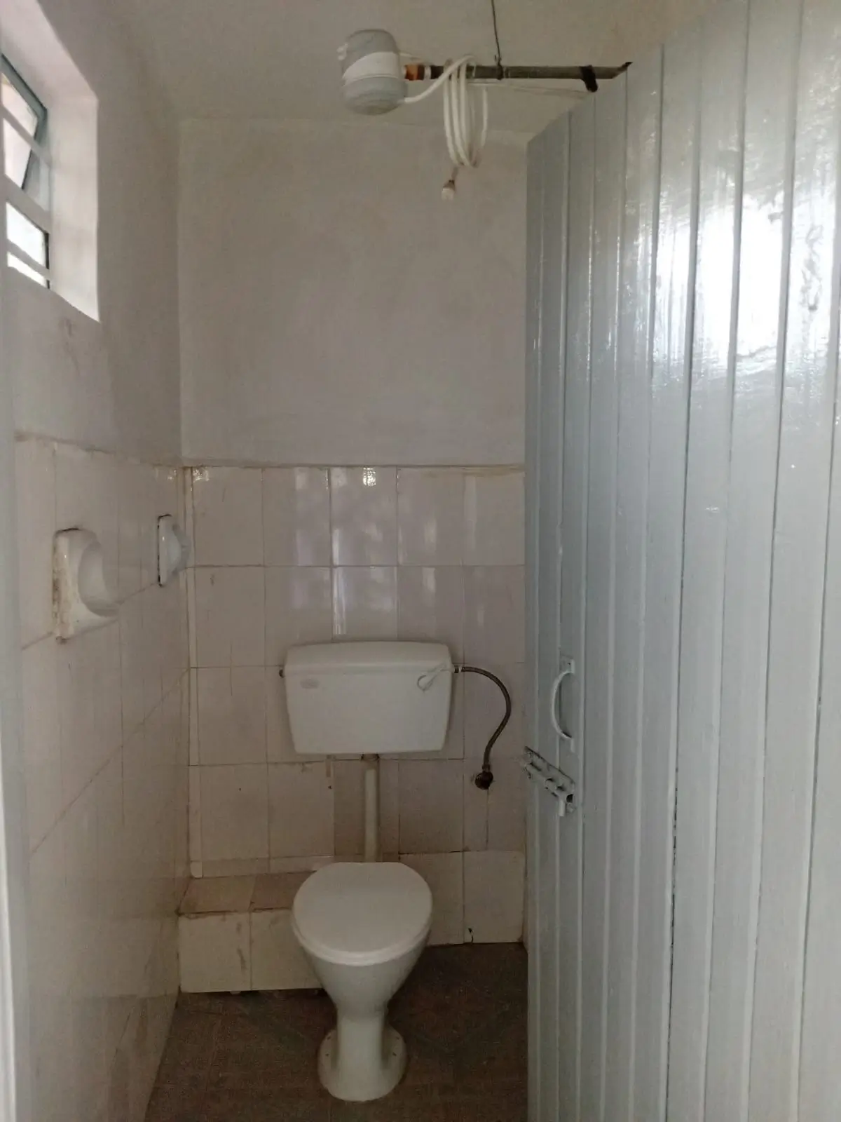 Small bathroom with toilet, sink, and shower cubicle