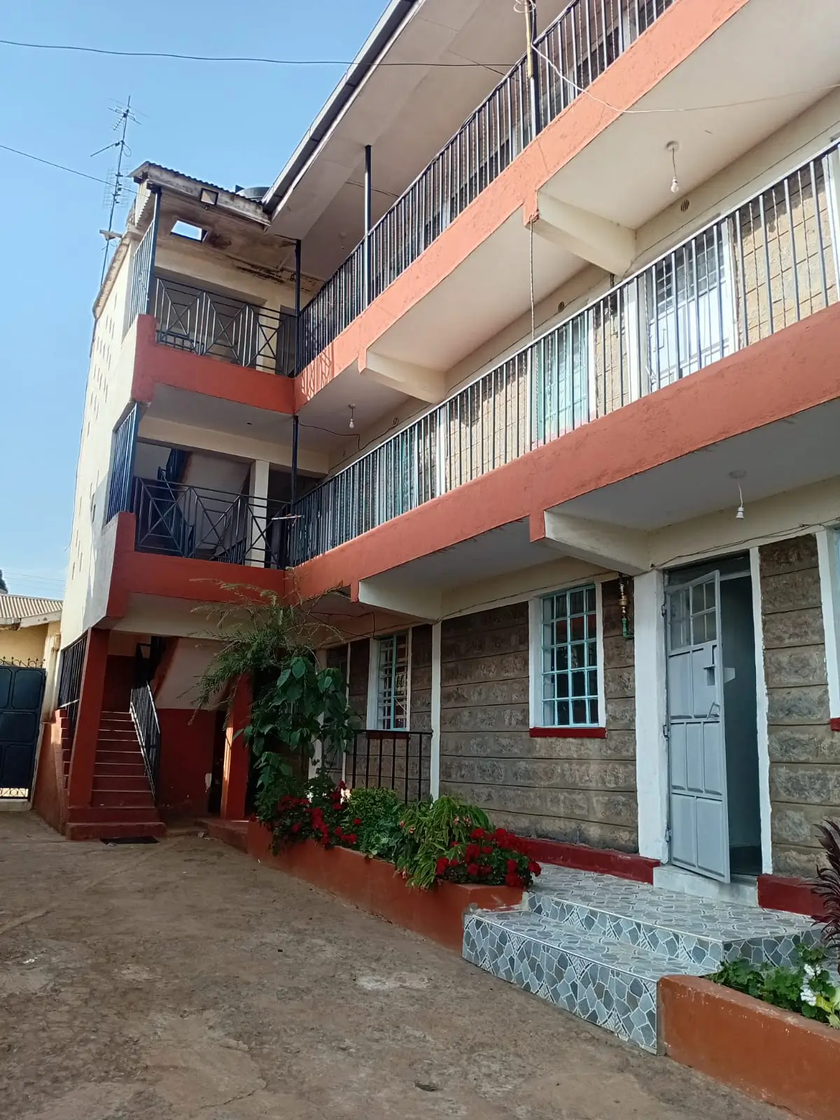 Multi-story residential building with red and stone facade
