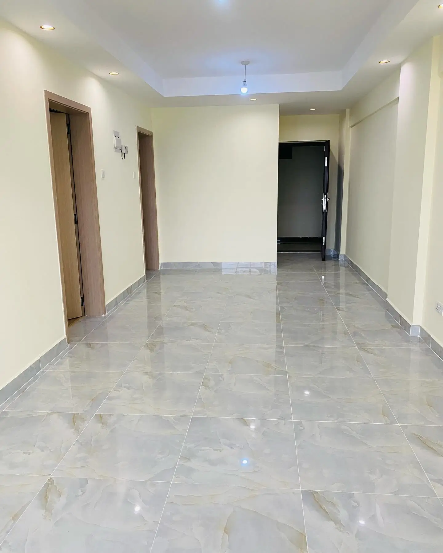 Bright corridor with polished marble flooring and multiple doorways