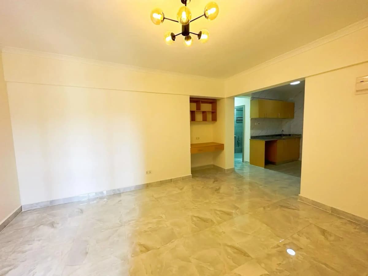Open-plan living area with kitchen visible in background