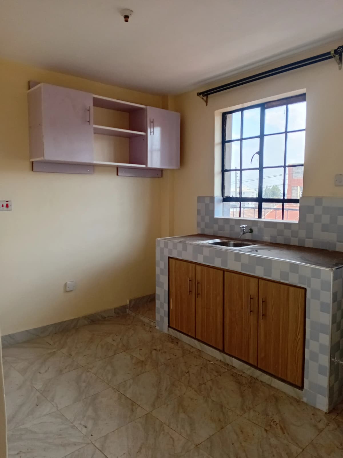 Compact kitchen with wooden cabinets and concrete countertop
