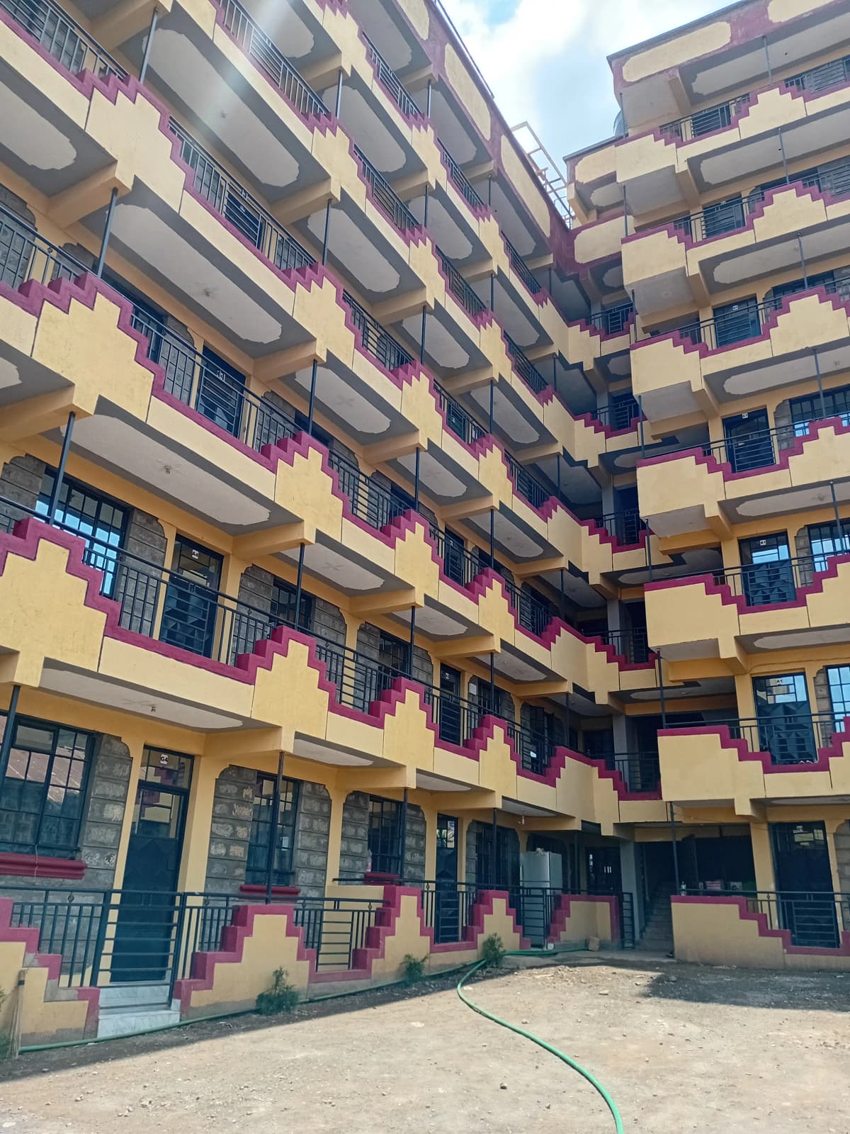 Multi-story residential building with yellow facade and balconies