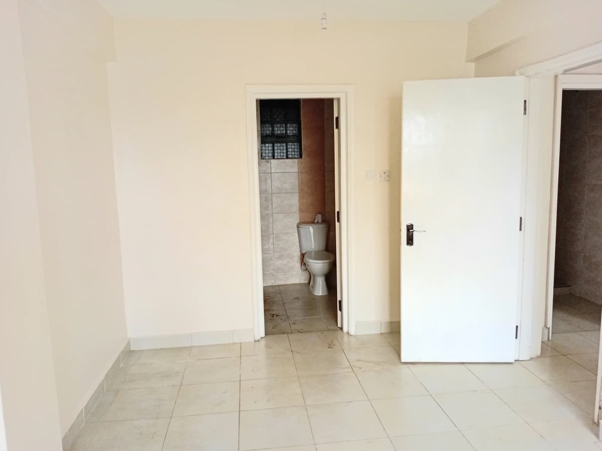 Bright hallway with multiple doorways and tiled flooring