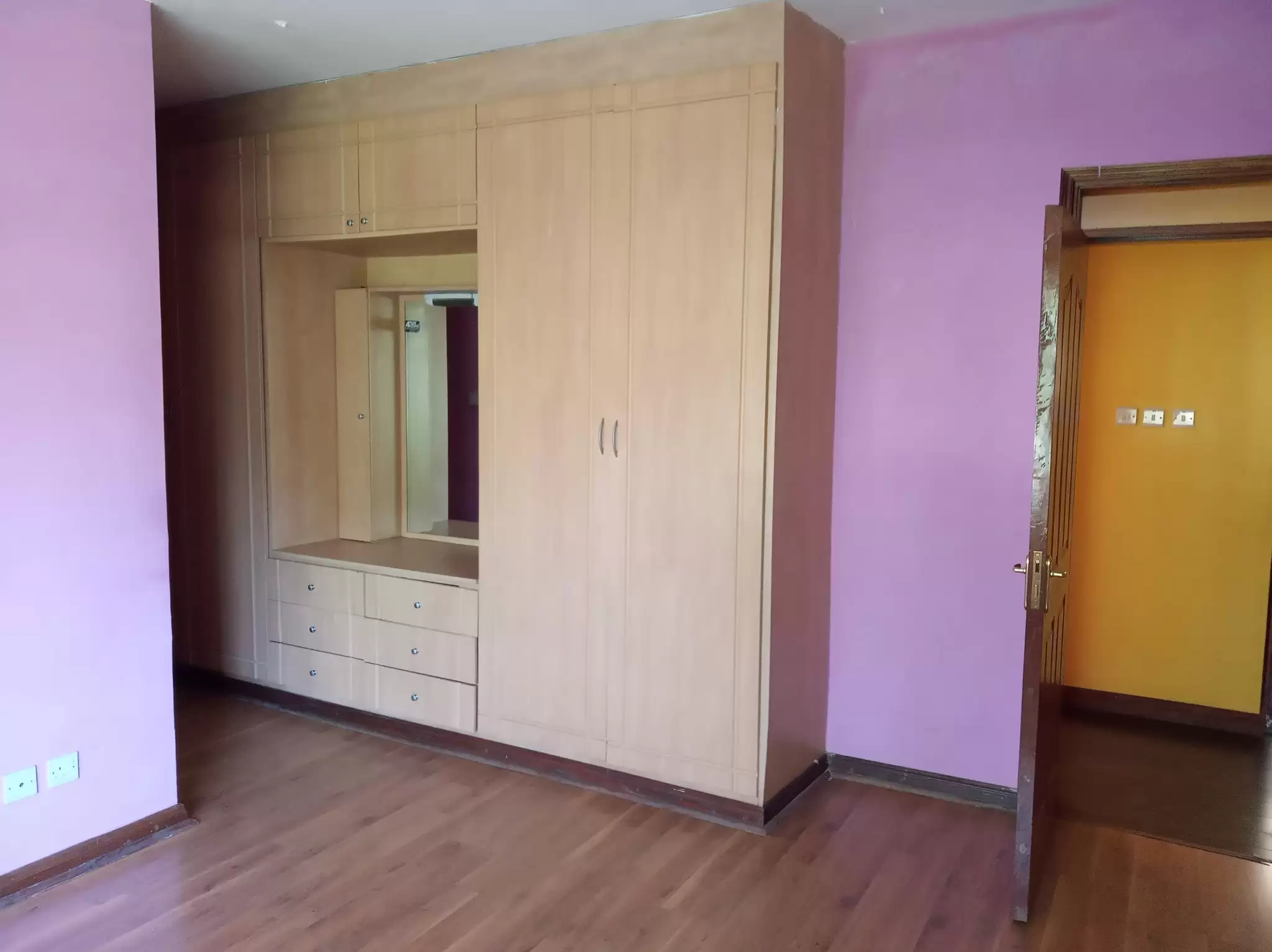Bedroom with built-in wooden wardrobe and mirror