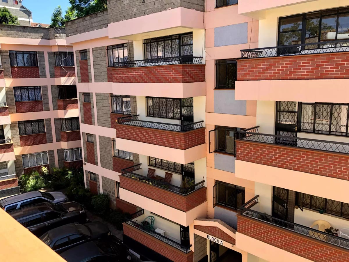Multi-story residential building facade with balconies and parking