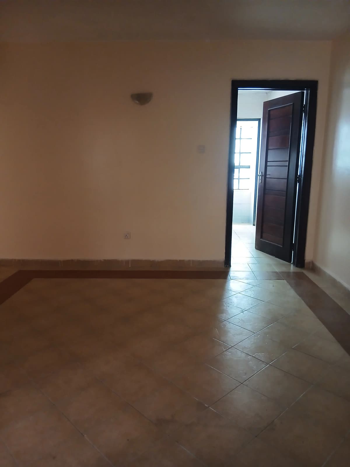 Empty living room with tiled flooring and open doorway
