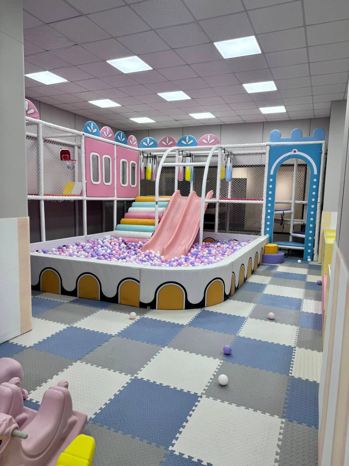 Colorful indoor children's play area with ball pit and slides