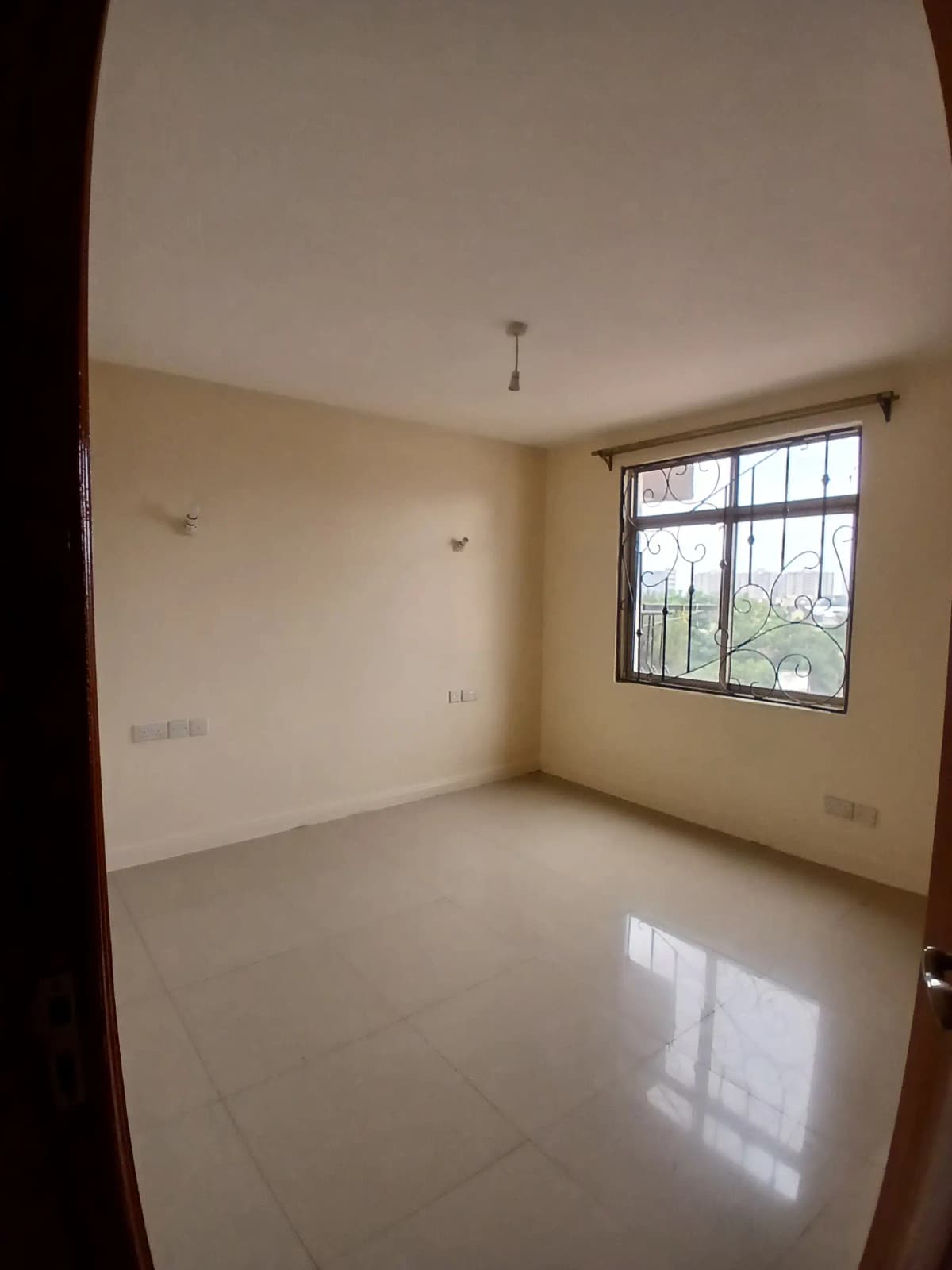 Bright empty bedroom with large window and polished floor