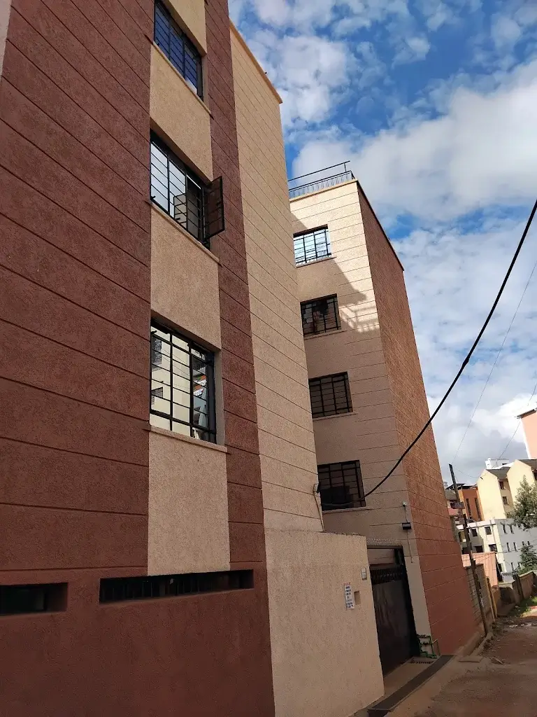 Multi-story residential building facade with brick and render finish