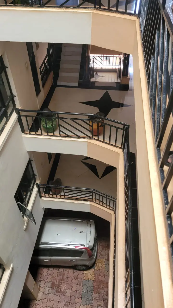 Covered parking bay with vehicle inside building courtyard