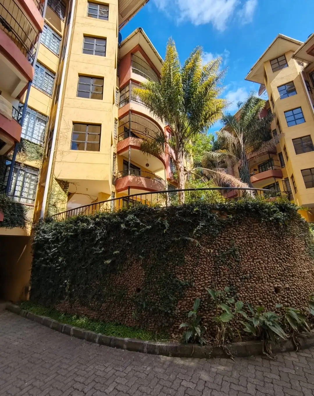Residential compound courtyard with ivy-covered walls and palm trees