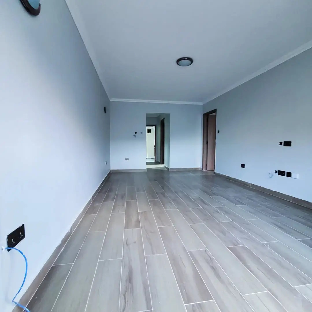 Empty living room with gray tile flooring, fresh paint