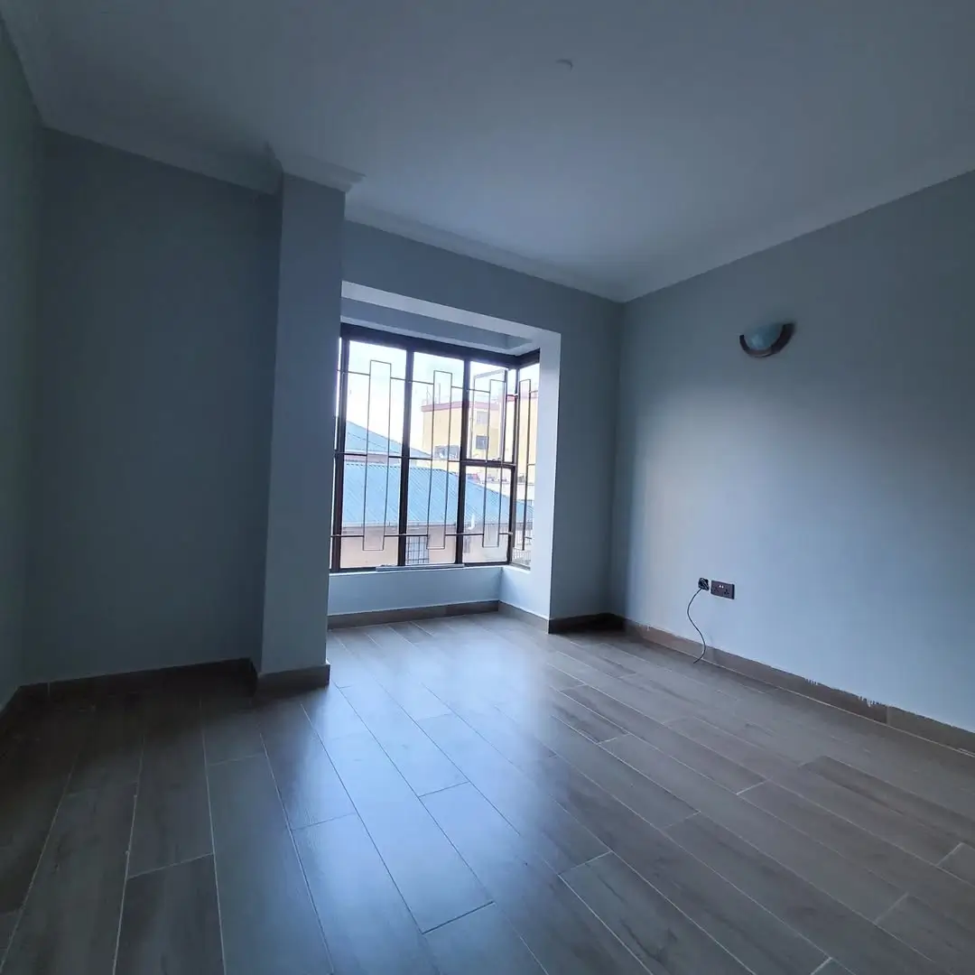 Spacious living room with barred window and partial flooring
