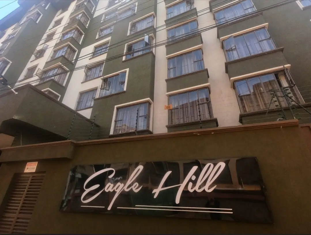 Multi-story residential building facade with Eagle Hill signage