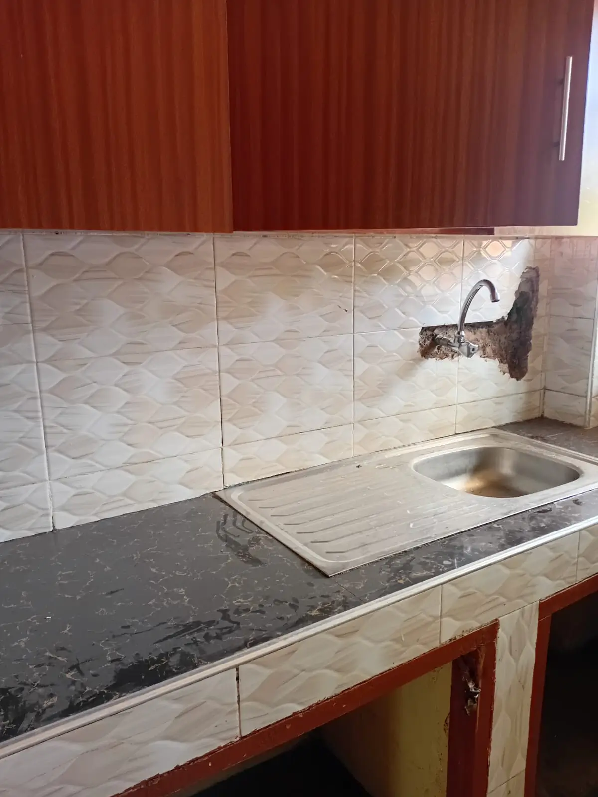 Compact kitchen with black countertop and tiled backsplash