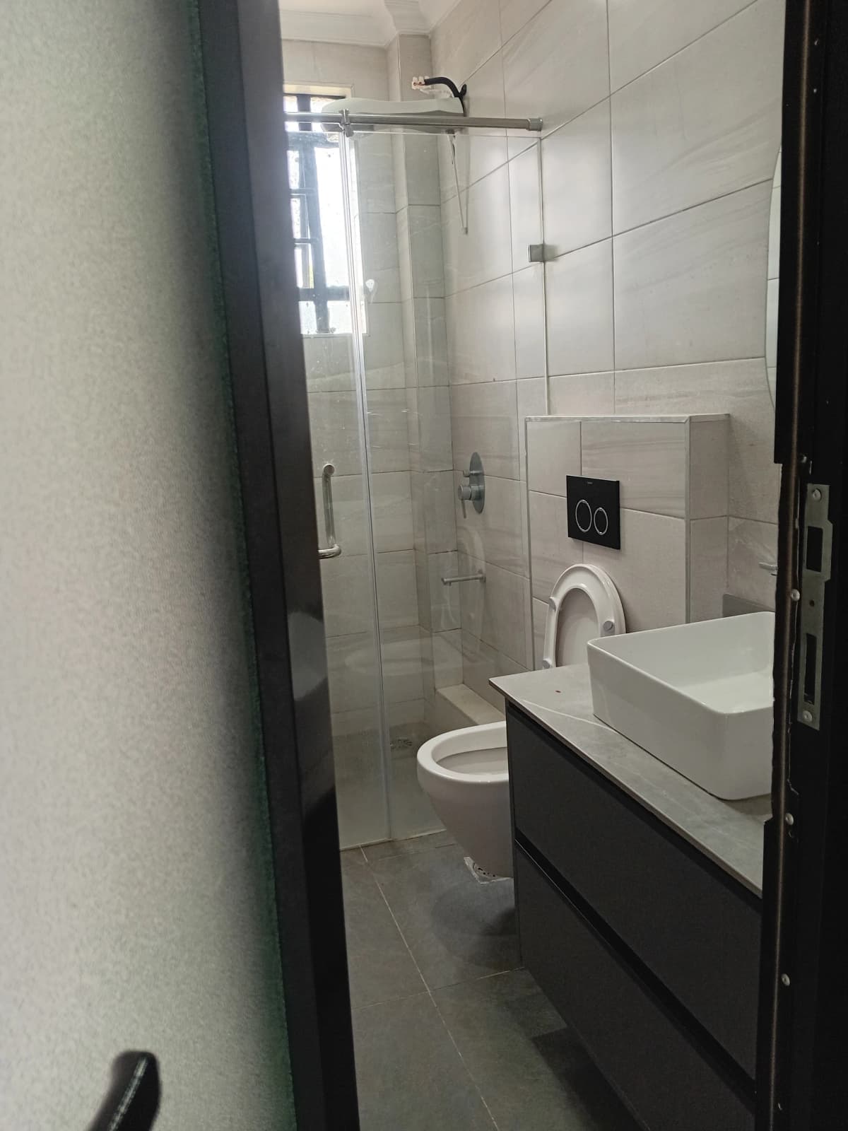 Modern bathroom with glass shower enclosure and black vanity