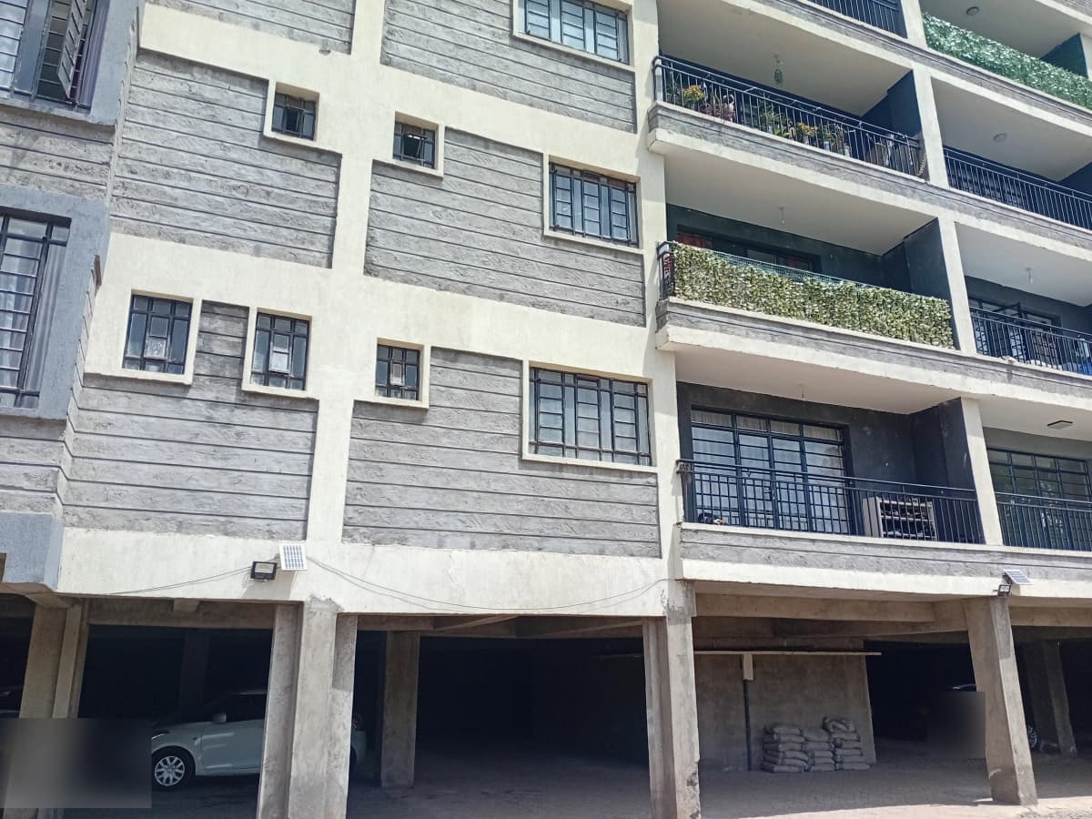 Multi-level apartment building with ground-floor parking bays