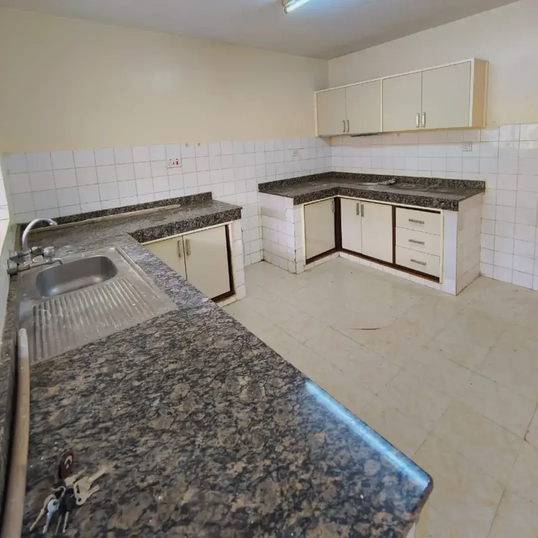 L-shaped kitchen with granite countertops and stainless sink